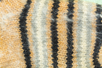 background, texture of light brown knitted wool fabric with black, white, gray stripes