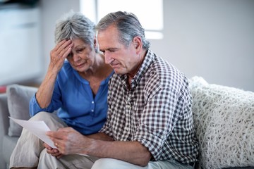 Worried senior couple checking the bills