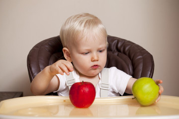 Fototapeta premium Two year baby boy sitting at the dinner table