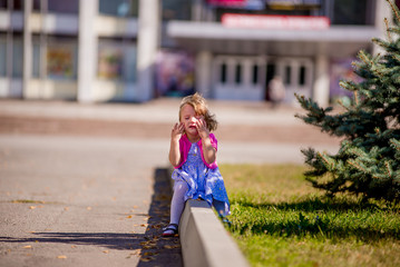 Beautiful sad little girl crying, on summer background.