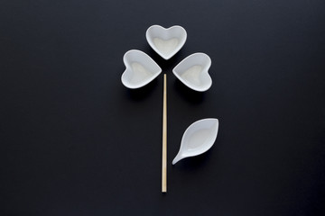Fiore composto da bacinelle a forma di cuore, bacchetta da sushi e bacinella per salsa di soia su...