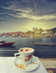 cup of coffee with Porto riverside on a background. Travel concept