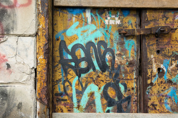 Stara zardzewiała brama z graffiti