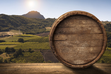 corkscrew and wooden barrel, vineyard on background