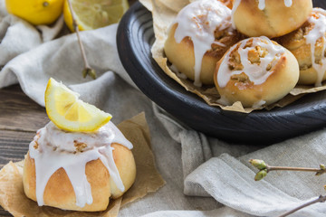 Cinnamon rolls with lemon glaze in wooden plate