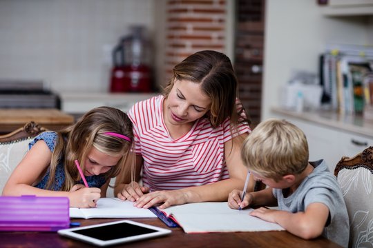 Mother Helping Kids With Their Homework