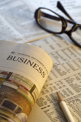 Glasses on newspaper and pencial.