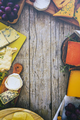 Cheese - different types of cheese on a wooden background (filtered)