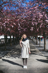 girl standing in the garden of flowering trees