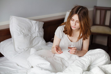 Obraz na płótnie Canvas Girl On Bed Taking Pill With Water Glass In Bedroom