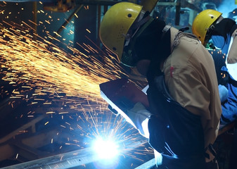MIG welder uses torch to make sparks during manufacture of metal equipment.