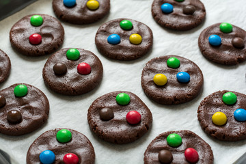 Preparing homemade chocolate cookies decorated with colored candy drops