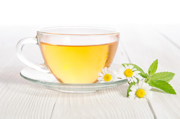 Cup of medicinal chamomile tea on the wooden table