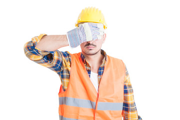 Portrait of attractive engineer covering his eyes
