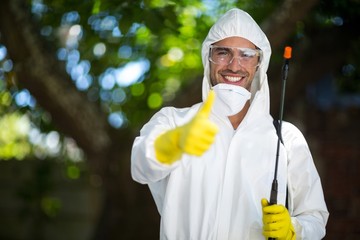 Man showing thumbs up while holding insecticide sprayer 