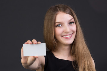 young beautiful girl holding a business card in hand