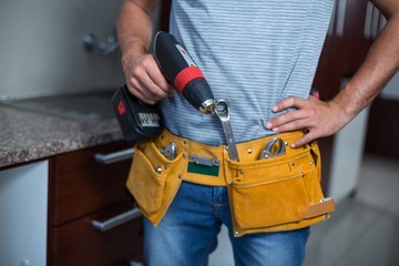 Midsection of man holding cordless hand drill 