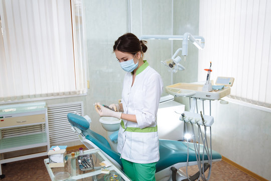 Dentist woman with medical instruments in the dental office doing procedures