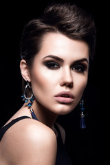 Beauty Fashion Model Girl with short hair. Brunette Model Portrait. Short haircut. Sexy Woman Makeup and Accessories. Isolated on black. Hair cut. Earrings