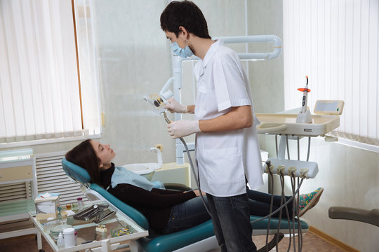 Dentist man making procedures with his patient in dental office