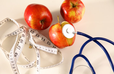 Stethoscope with red apples on a white background