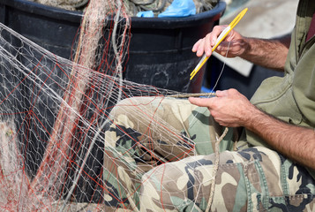 mani al lavoro su rete da pesca