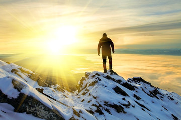 The man to stand on mountain top at sunrise