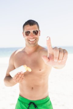 Portrait of man applying sun cream
