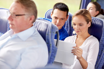 happy couple with tablet pc in travel bus