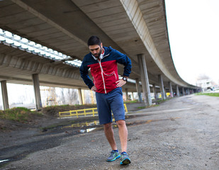 Exhausted man walking after jogging.Taking a break.