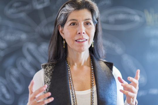 Hispanic businesswoman talking in office