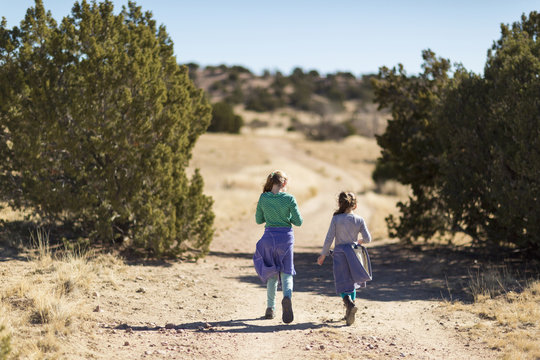 Caucasian girls walking on dirt path