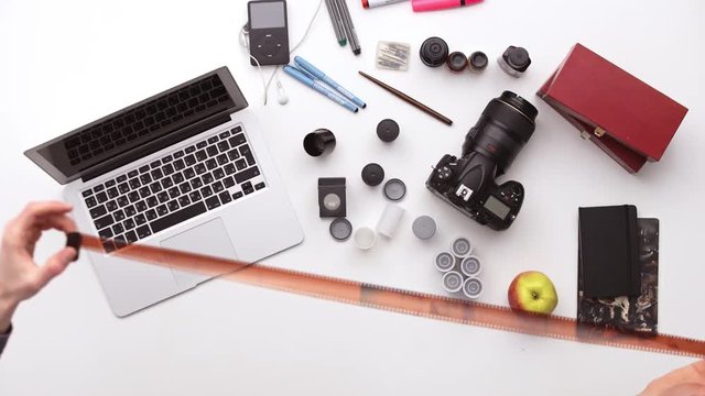 Photographer prepares his desk for work surrounded by a lot of things. Upview
