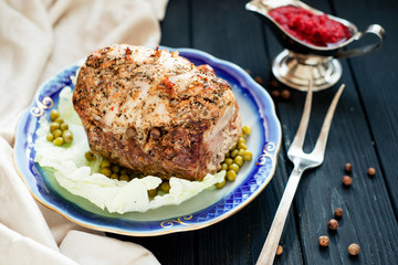 
meat , home baked ham or 
cold boiled pork with spices , lettuce, green peas and sweet and sour berry sauce on a wooden background