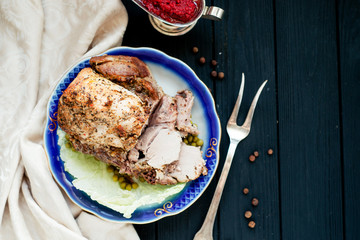 
meat , home baked ham or 
cold boiled pork with spices , lettuce, green peas and sweet and sour berry sauce on a wooden background