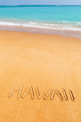 Inscription Hawaii made on beautiful beach by the blue sea