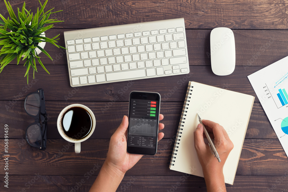 Aufkleber hand checking stock graph on phone and write note