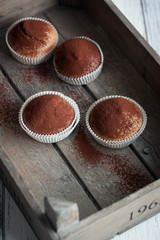 Muffins with spelt flour and cocoa in a wooden box on a table, closeup