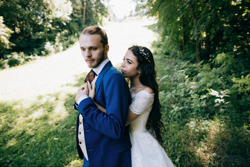 Happy sensual Bride and groom at wedding Day embracing with love. Romantic young couple celebrating their marriage in forest