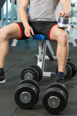 Fototapeta na wymiar Athlete preparing himself for lifting weights in the modern gym