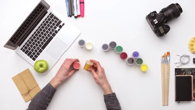 Photographer prepares his desk for work surrounded by a lot of things. Upview