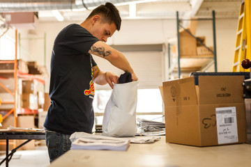 Worker packing garment in screen print workshop