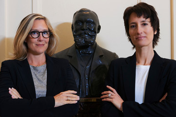 Portrait of confident professional women next to statue