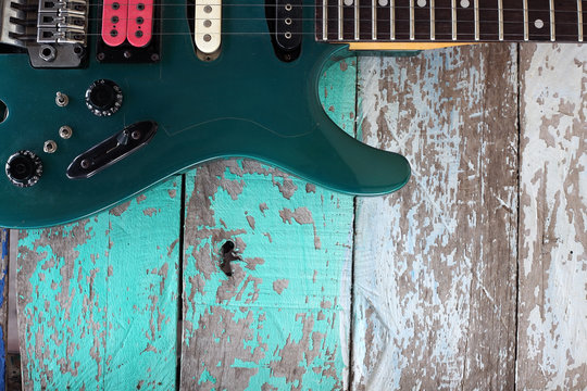 colorful guitar with grunge wooden panel background.