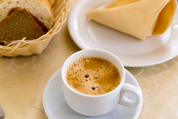 White cup of coffee on  table in a restaurant