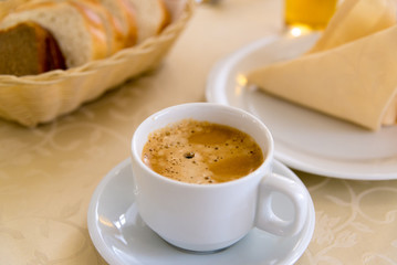 White cup of coffee on  table in a restaurant
