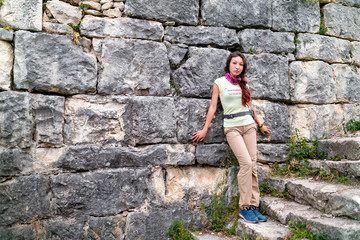 tourist girl looks at Anakopia fortress from the wall of an anci