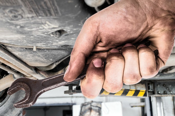 Dirty hand holding wrench.Car servis.
