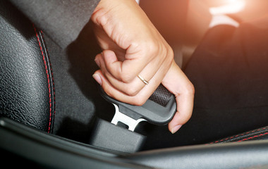 Business woman hand fastening a seat belt.