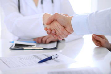 Doctor and patient handshaking. Hands close-up